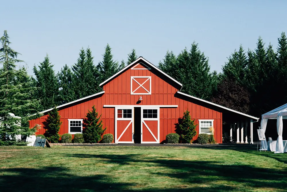 A red barn standing on a mown lawn